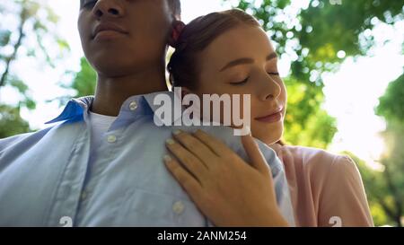 Close-up of young couple in park, teen girl leaning on petit ami, l'amour de l'épaule Banque D'Images