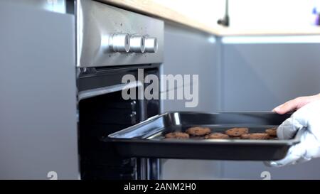 Woman putting chocolate cookies au four, recettes de pâtisserie maison, confection Banque D'Images