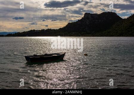 Petit bateau dans le lac Vouliagmeni près de Loutraki, Grèce, au coucher du soleil Banque D'Images