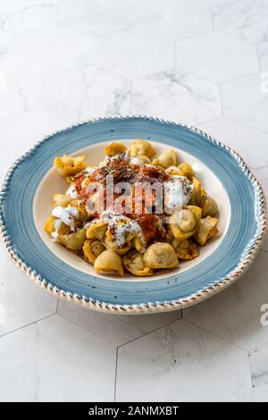 Pelmeni russes maison poêlée de quenelles avec de la charcuterie, des yaourts, de la sauce tomate et les épices. Aliments sains traditionnels. Banque D'Images