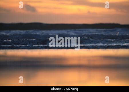 (Selective focus) vue imprenable de vagues se brisant sur une plage magnifique et spectaculaire au cours d'un romantique coucher de soleil. Banque D'Images