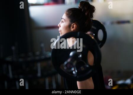 Sport femme athlétique en soulevant des poids dans la salle de sport Banque D'Images