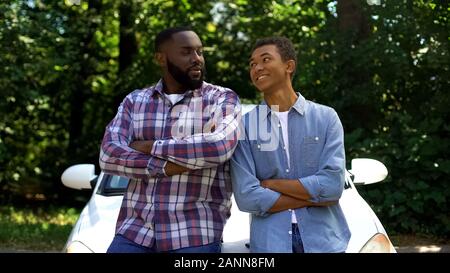 Smiling african père et fils souriant sur fond de voiture, l'aventure Banque D'Images