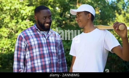 Papa encourageant son holding Baseball bat, le sport loisirs, famille passe-temps de connexion Banque D'Images