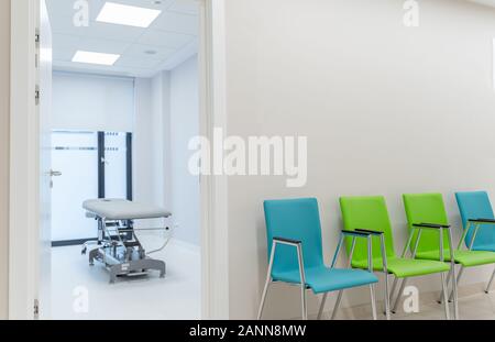 Esthétique et propre salon moderne de massage privé, soin de la peau et des ongles. Table de massage dans la salle de clinique visible de la salle d'attente. Banque D'Images