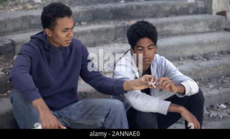 Deux adolescents noirs de fumer de la marijuana weed escaliers, rue, la toxicomanie Banque D'Images