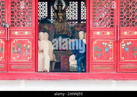 Un chinois peinture les statues de bouddha à l'intérieur du Temple Jile à Harbin en Chine. Banque D'Images