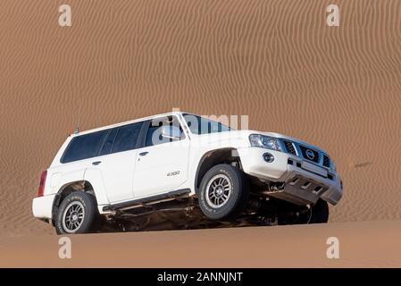 white nissan patrouille super safari escalade dune sable barbotage sable autour dans dasht e lut ou sahara désert Banque D'Images