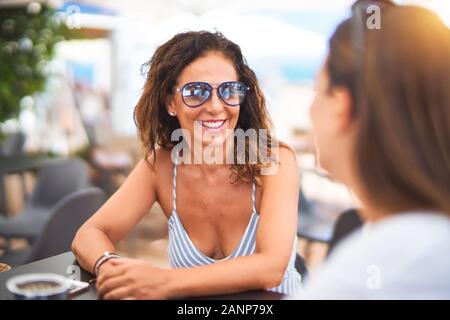 Belle Mère et fille assis à une terrasse de restaurant parlant et souriant Banque D'Images