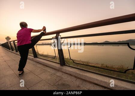 Tai Chi à l'aube dans la ville chinoise de Zhaoqing - populaires parmi les habitants qui se rassemblent, comme le soleil se lève. Ici, les personnes âgées pratiquer l'art. Banque D'Images