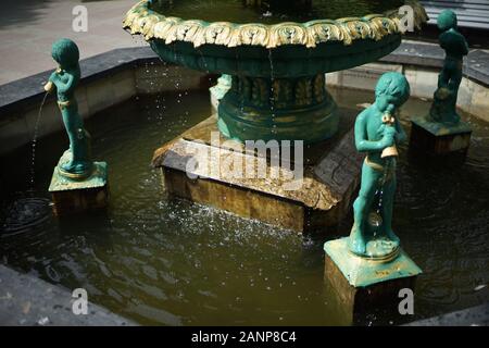 Fontaine avec cupidon garçons qui verse de l'eau du navire. Banque D'Images