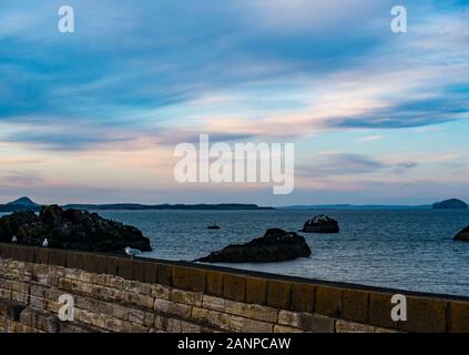 Dunbar, East Lothian, Ecosse, Royaume-Uni, 18 janvier 2020. Météo France : Coucher de soleil sur le port de Dunbar. Des couleurs dans le ciel vers l'dômes volcaniques de la Bass Rock dans le Firth of Forth et Berwick Law au coucher du soleil Banque D'Images