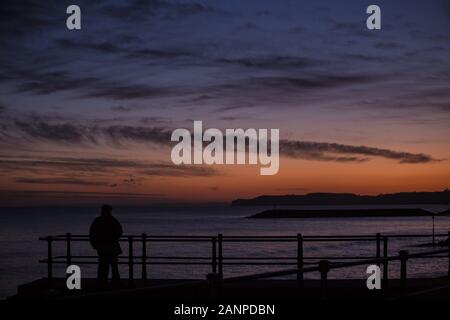 La ville de Sidmouth, Devon, 18 janvier 2020 tête de personnes sur le front de Sidmouth à apercevoir le magnifique coucher de soleil qui s'est terminée un jour froid mais claire dans le Devon. Central Photo/Alamy Live News Banque D'Images