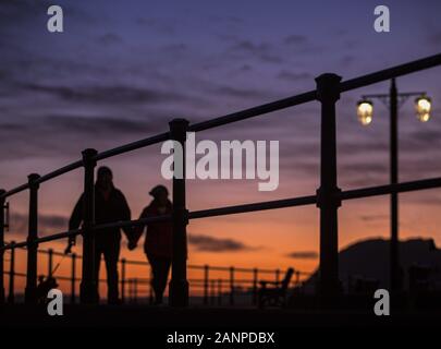 La ville de Sidmouth, Devon, 18 janvier 2020 les gens à pied le long du front de Sidmouth sous un magnifique coucher de soleil qui s'est terminée un jour froid mais claire dans le Devon. Central Photo/Alamy Live News Banque D'Images