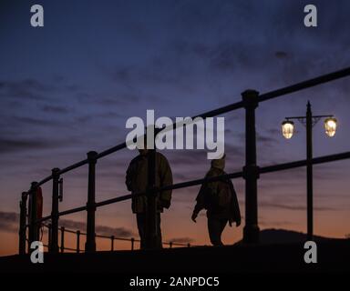 La ville de Sidmouth, Devon, 18 janvier 2020 les gens à pied le long du front de Sidmouth sous un magnifique coucher de soleil qui s'est terminée un jour froid mais claire dans le Devon. Central Photo/Alamy Live News Banque D'Images