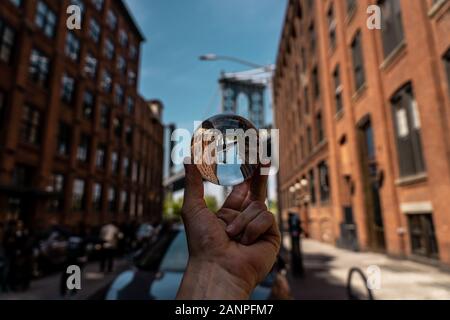 Lensball vue d'une des tours du pont de Manhattan à partir de la rue du quartier de DUMBO, Brooklyn, NYC, crystal ball libre Banque D'Images