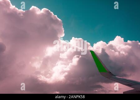 Les nuages roses, couleur émeraude Ciel, vue depuis la fenêtre d'un avion, l'abstraction. Banque D'Images