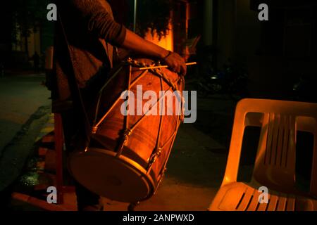 Gurgaon, Inde, vers 2020 - Photo d'un tambour ou un Dhol menées autour d'une personne la nuit. Le dhol est accroché autour du cou et frappé par un CIST Banque D'Images