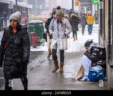 New York, États-Unis, 18 janvier 2020. Les passants passent devant un sans-abri à New York Upper East Side, pendant une tempête. Credit : Enrique Shore/Alamy Live News Banque D'Images