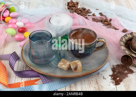 Le café turc traditionnel dans la tasse de porcelaine set,un verre d'eau et loukoums, amande coloré bonbons sur surface avec les grains de café. Une fête (f Banque D'Images