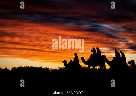 Une silhouette spectaculaire au coucher du soleil causée par un groupe de touristes lors d'une balade dans l'arrière-pays de l'Australie. Yulara, Territoire Du Nord, Australie Banque D'Images