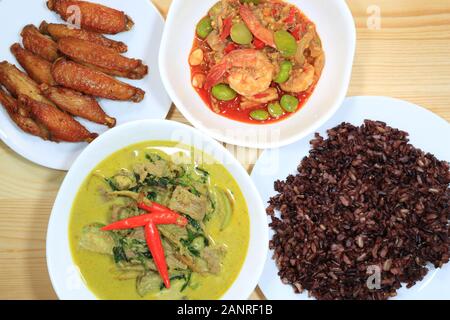 Repas de produits locaux, Thaï Curry vert avec du boeuf, des ailes de poulet épicées frits, sautés, Parkia écrous avec les crevettes et le riz Banque D'Images