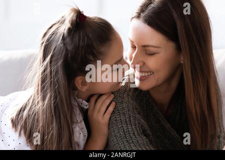 Smiling maman et petite fille s'amuser partager secrets Banque D'Images