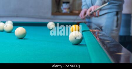 Green table de billard avec des boules blanches. Jeune homme jouant au billard Banque D'Images