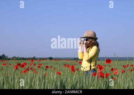 La petite fille est prise de photos dans le pré saison printemps Banque D'Images