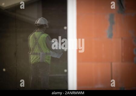 Architecte Ingénieur avec casque de protection au travailleur de la construction de la chambre d'arrière-plan du site Banque D'Images