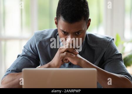 Souligné African American businessman looking at laptop screen close up Banque D'Images