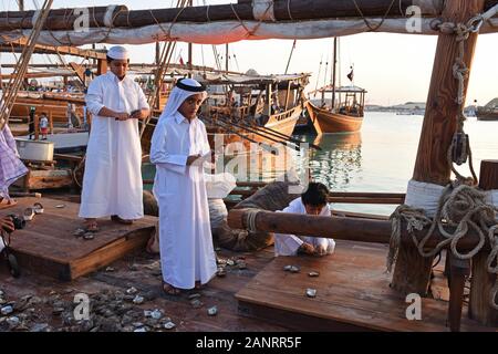 Les garçons du Qatar ouvrir les huîtres sur le dhow, Katara dhaw traditionnel festival, Doha, Qatar. Banque D'Images