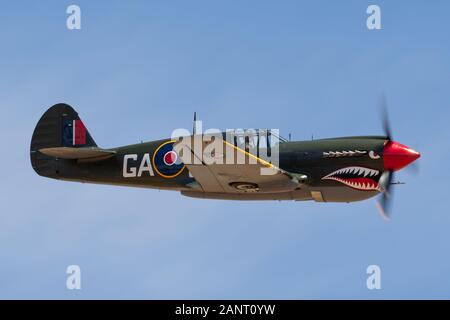 Curtiss P-40N Kittyhawk La Seconde Guerre mondiale avions VH-ZOC voler contre un ciel bleu. Banque D'Images