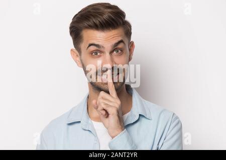 Beau jeune homme montrant geste hush portrait. Banque D'Images