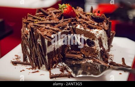 L'accent sélective fait maison fraîchement préparés en couches délicieux gâteau au chocolat décoré avec des fraises et du chocolat râpé. Dans la restauration, en bonne santé Banque D'Images