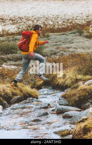 Trail Running Man crossing river adventure vacances voyage randonnée active healthy lifestyle outdoor runner avec sac à dos dans les montagnes de la Norvège Banque D'Images