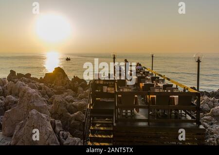 Restaurant en bord de mer au coucher du soleil méditerranéen à Cefalu. Le Cefalu historique est une destination touristique majeure de la Sicile. Banque D'Images