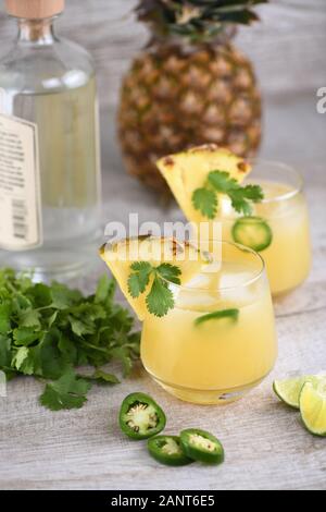 Tequila cocktail avec le jus d'ananas, les tranches de jalapeno et la coriandre, refroidi à l'aide de glace Banque D'Images