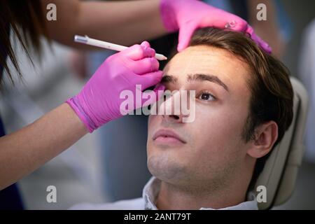 Bel homme ayant un traitement des rides du visage, les cosmétiques concept Banque D'Images