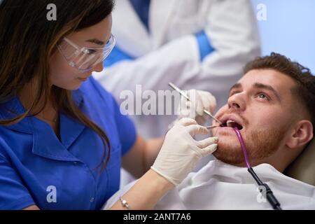 Prendre soin de sa fixation dame dentiste dents du patient, patient et dentiste concept Banque D'Images