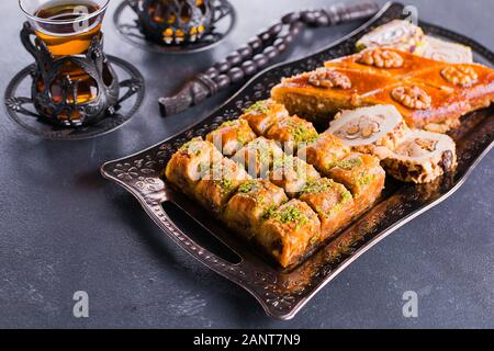 Assortiment de douceurs orientales. Baklava et deux tasses de thé sur une table de béton bleu. Image en gros plan Banque D'Images