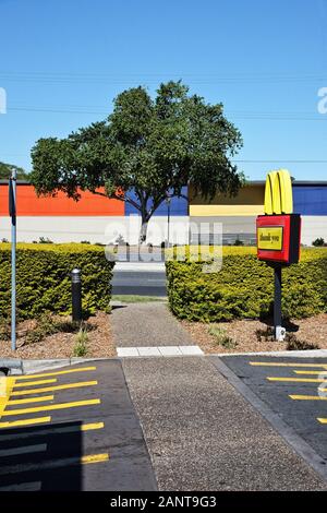 Une scène « nouvelle topographique » a été prise sur un parking Fast food, des lignes, des couleurs et une géométrie bloquées et un M jaune contraste un ciel bleu Banque D'Images