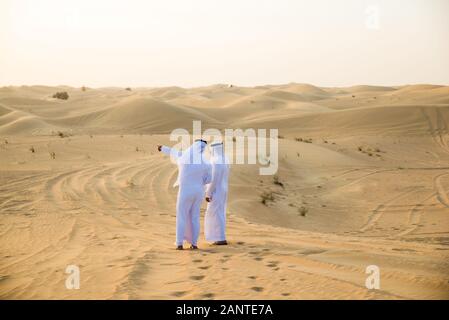 Les hommes d'arabie witk kandora marcher dans le désert - Portrait de deux adultes avec moyen-orientale robe arabe traditionnelle Banque D'Images