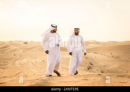 Les hommes d'arabie witk kandora marcher dans le désert - Portrait de deux adultes avec moyen-orientale robe arabe traditionnelle Banque D'Images