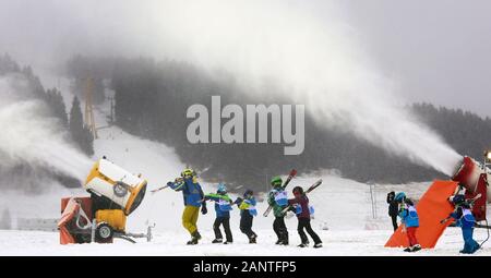 Oberwiesenthal, Allemagne. 19 Jan, 2020. Les enfants ayant des skis sur leurs épaules à pied avec leur moniteur de ski le long du Fichtelberg entre deux canons à neige. En raison de la faible neige dans les derniers jours, les canons à neige fonctionner jour et nuit. Credit : Waltraud Grubitzsch/dpa-Zentralbild/dpa/Alamy Live News Banque D'Images