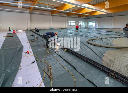 La chape est coulée sur un site de construction à l'intérieur d'un grand bâtiment de l'usine Banque D'Images