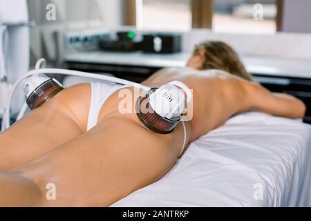 Massage du corps sous vide. Les zones à problèmes dans la cuisse et les fesses s'amincissant. Close-up de jambes de jeune femme sur une table de massage, massage anti-cellulite de Banque D'Images