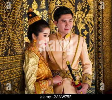 Jeune couple pose pour photo de mariage portant des costumes traditionnels, Wat Xien Thong temple, Luang Prabang, Laos Banque D'Images