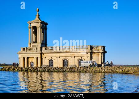 Normanton Church situé sur les rives de Rutland Water avec un ciel bleu ciel derrière et classic voitures garées à côté Banque D'Images