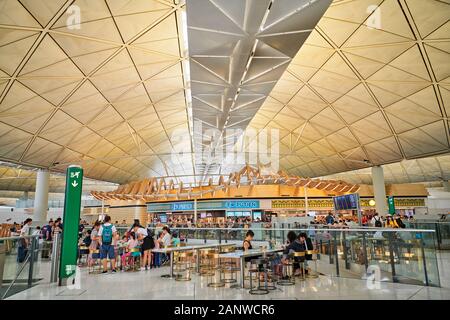 Hong Kong : les touristes dans les restaurants dans la zone de transit à l'intérieur de l'Aéroport International de Hong Kong avec son architecture futuriste Banque D'Images